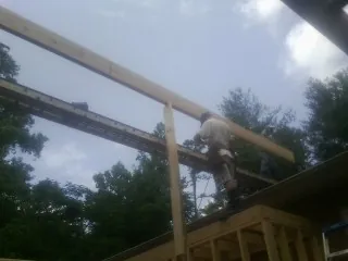 Carpenter setting a ridge beam over a new addition frame — Ice Dam Removal by Roofing Brothers in Mingo