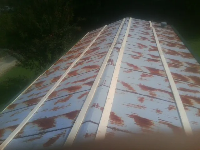 Rusted metal roof panels with new wood purlins before replacement — Storm Damage Roof Repair in Mingo by Roofing Brothers