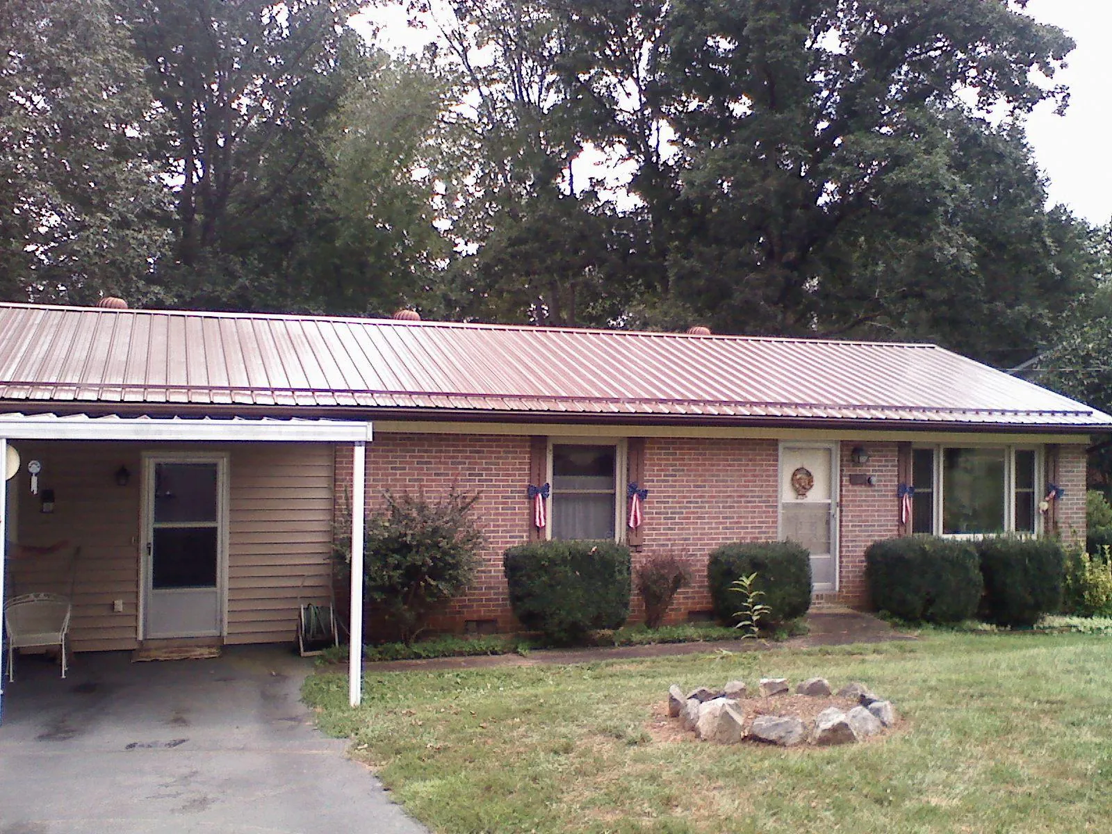 Bronze metal roof and carport on a brick ranch home — Roof Repair work by our crew in Mingo